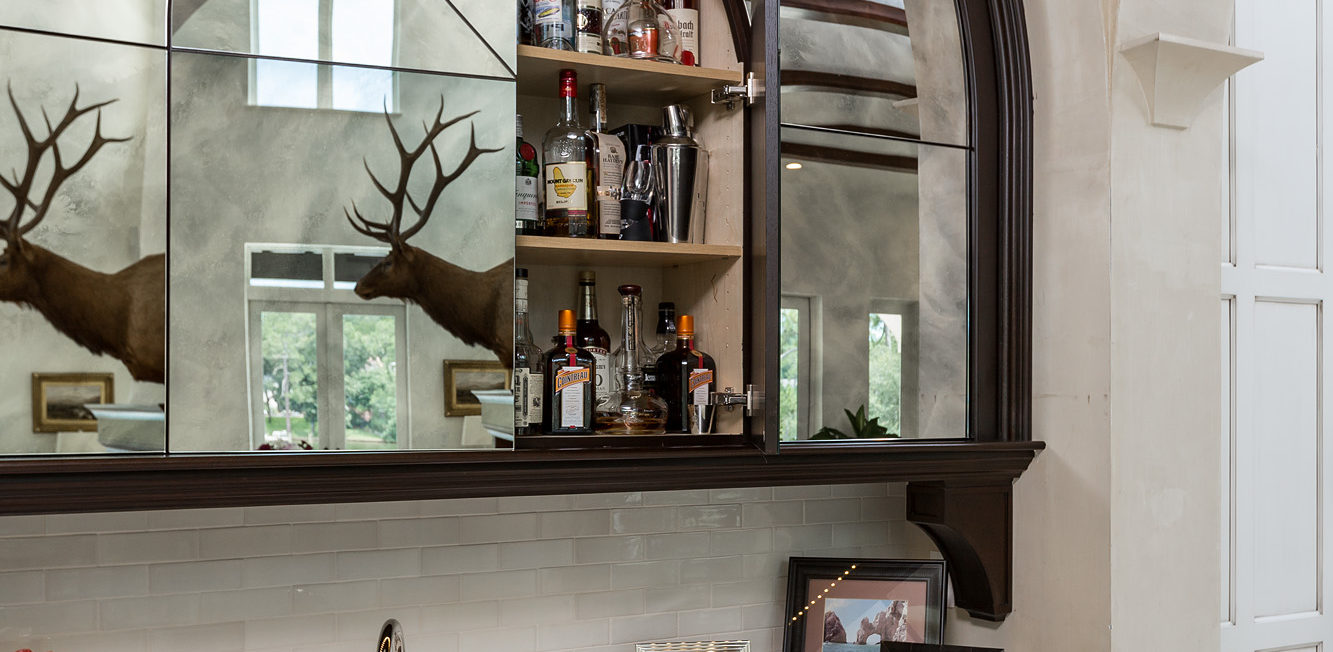 Custom built bar with a dark stained walnut and slab mirror doors