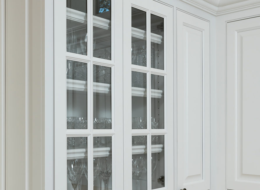 White mullion frame doors inset into upper cabinet row with glass inserts.
