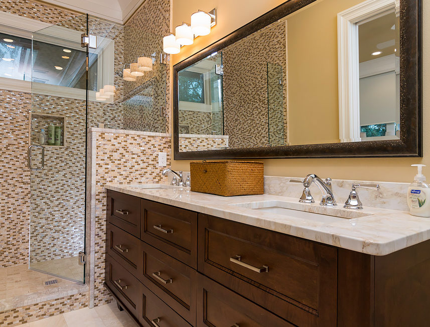 Dark stained bathroom vanity with full overlay cabinetry and recessed panel drawer fronts